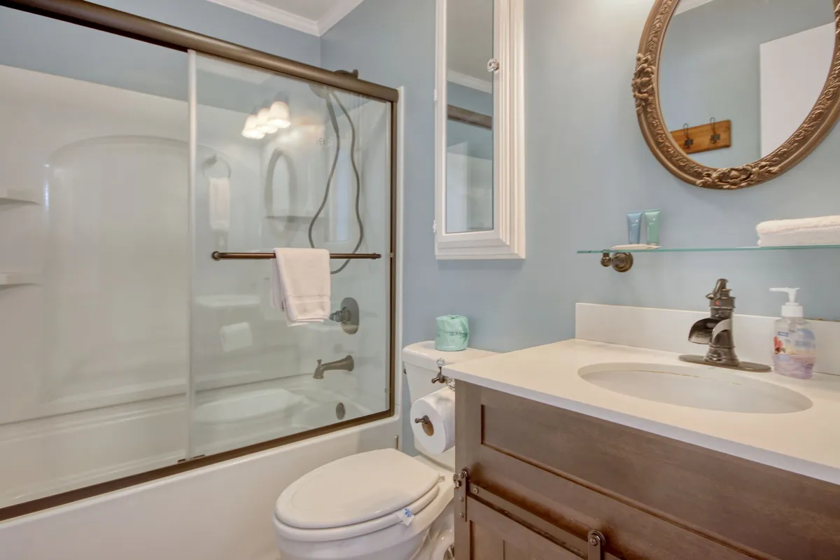 A fresh, inviting bathroom with a modern shower area, a well-lit mirror, and a sink. The clean design evokes a spa-like experience, ideal for personal grooming and relaxation after a day out.